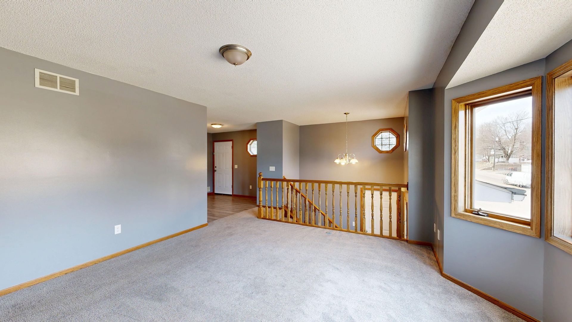 Bright and open interior with windows and staircase, ideal for real estate listings.